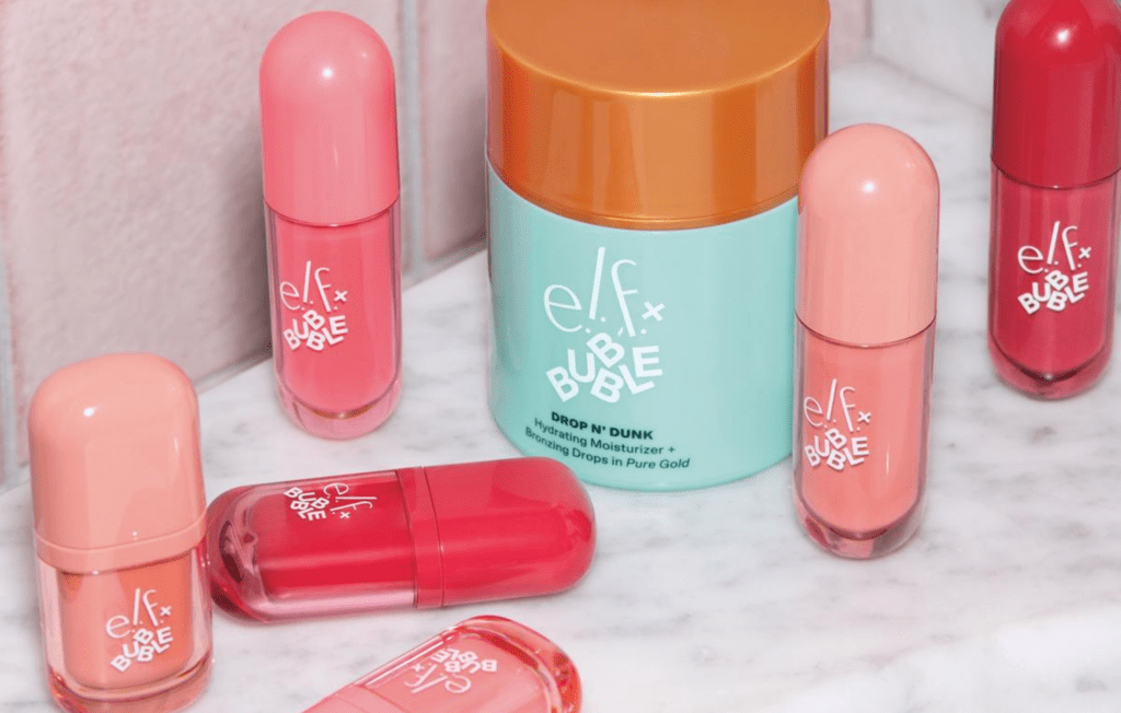 Assorted e.l.f. x Bubble makeup and skin-care products, including blush, lip and bronzing formulas, arranged on a marble surface.